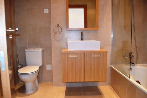 a bathroom with a toilet and a sink and a mirror at Apartamento Atlantico in Sucina