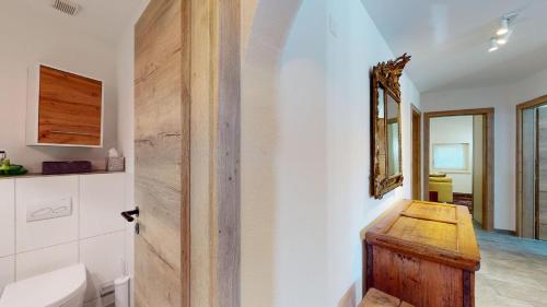 a bathroom with a toilet and a wooden door at Abitaziun La Dmura 12 - Samedan in Samedan