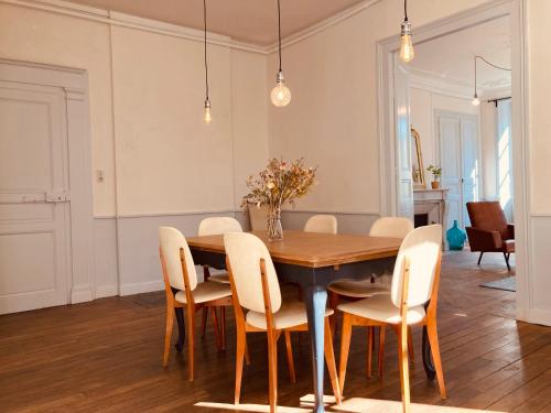 una sala da pranzo con tavolo e sedie in legno di l'Albuconis7 Appartement 160m2 ad Aubusson