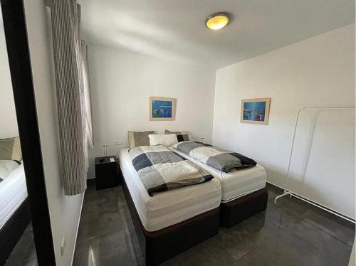 a bedroom with two twin beds in it at lux 2 kmr app Stella Blanca met zwembaden airco en zeezicht in Fuengirola