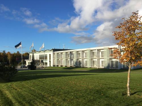 a white building with flags in front of it at Raadimõisa Hotell in Tartu