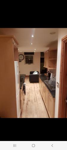 a kitchen with a refrigerator and a couch in a room at Spacious 2 bed appartment next to BAE with spa bath in Barrow in Furness