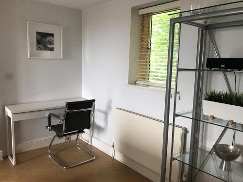 ロンドンにあるRoomspace Serviced Apartments - The Courtyardの椅子とガラスの棚が備わる部屋