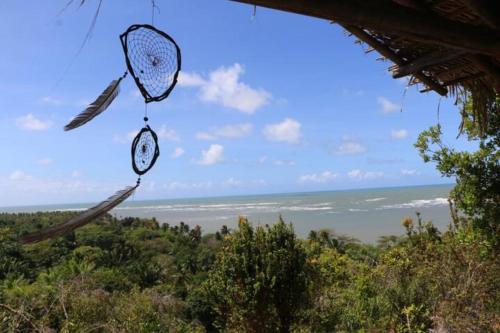 ein Drachen hängt von einer Hütte mit dem Ozean im Hintergrund in der Unterkunft Mirante Morere in Moreré