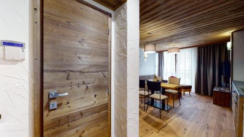 a living room and dining room with a wooden wall at Apartment Indianne in Demanovska Dolina