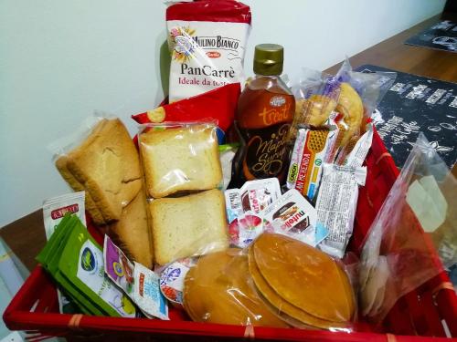 a red basket filled with food and bread and drink at B&B Maison Villa Vittorio in Avella
