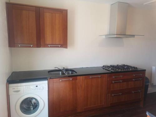 a kitchen with a stove and a washing machine at Spacious and warm 2 bedroom apartment sleeps up to 5 in Athy
