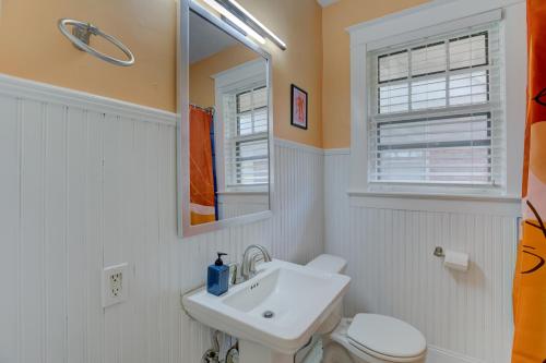 a bathroom with a sink and a toilet and a mirror at Vintage Vibes in Walkable Midtown - Spacious Bungalow with 6 beds in Central Location in Memphis