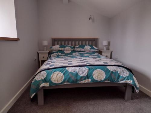 a bedroom with a bed with a blue and white comforter at The Old Dairy in Dunball