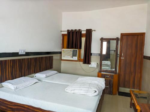 a bedroom with two beds and a mirror at Hotel Goverdhan - Walking to Raja Ki Mandi Railway and 3km from ISBT in Agra