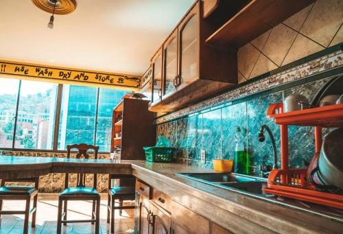 a kitchen with a sink and a counter with stools at The Rooftop Bolivia in La Paz