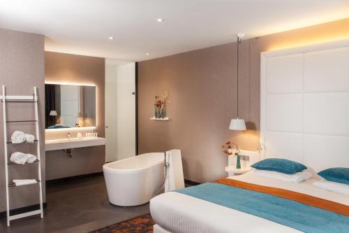 a bedroom with a bed and a tub and a sink at Van der Valk hotel Veenendaal in Veenendaal