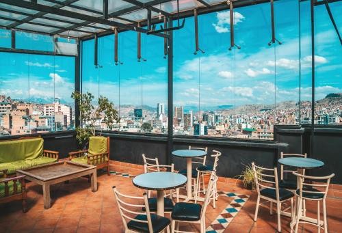 een balkon met tafels en stoelen en uitzicht op de stad bij The Rooftop Bolivia in La Paz