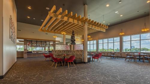 een restaurant met tafels, stoelen en ramen bij Hotel Spice & Sky Atlanta Perimeter in Atlanta