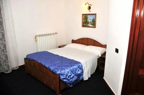 a bedroom with a bed with a blue and white blanket at Pensiunea Nordica in Statiunea Borsa