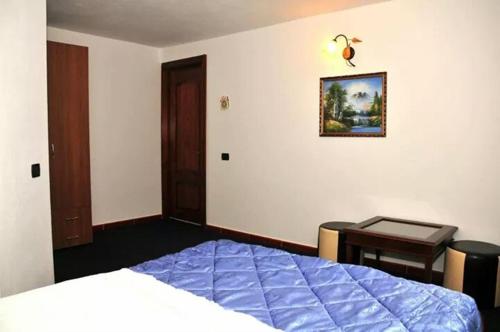 a bedroom with a bed and a table and a desk at Pensiunea Nordica in Statiunea Borsa