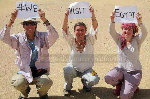 a group of three people holding up signs at Sakkara pyramid inn hotel in Cairo