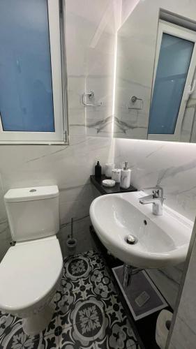 a bathroom with a white toilet and a sink at Valletta Home -Dar il-Kavallier Jacques de Quiqueran in Valletta