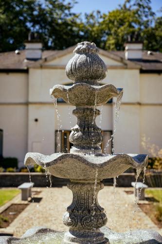 a stone fountain with water coming out of it at Escape Ordinary at Castle Hume in Enniskillen