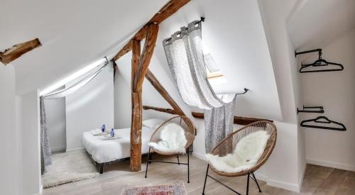 une chambre avec deux chaises, un lit et une fenêtre dans l'établissement Le Bohème, à Rouen