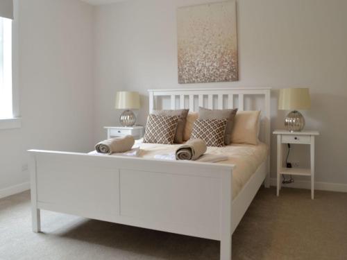 una cama blanca con almohadas en una habitación en Devon Hill, en Glenluce