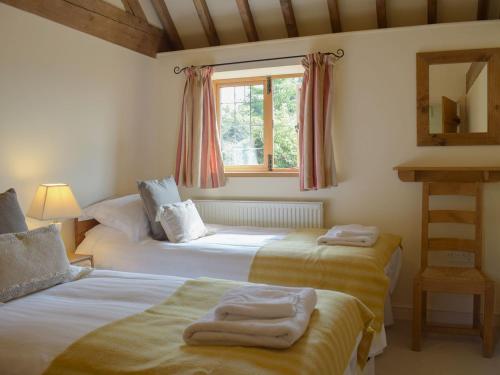 a bedroom with two beds and a window at Talog Barn-uk31366 in Tregynon