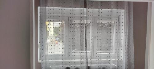 a window with white curtains in a room at Cazare Isa in Deva