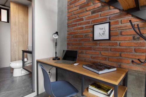 - un bureau avec un ordinateur portable sur un mur en briques dans l'établissement +MS +Único loft +Inmejorable ubicación +Arcos loft 1, à Laborcillas
