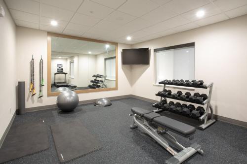 a fitness room with a gym with weights and a mirror at Holiday Inn Express Hotel & Suites Grand Junction by IHG in Grand Junction
