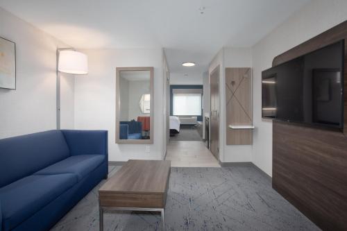 a living room with a blue couch and a tv at Holiday Inn Express Hotel & Suites Grand Junction by IHG in Grand Junction
