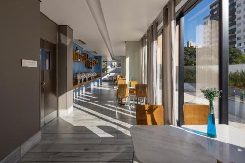 a hallway of a building with a table and chairs at Radisson Blu Belo Horizonte Savassi in Belo Horizonte