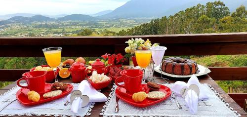 una mesa con una bandeja de comida y zumo de naranja en Chalé da Montanha com Ofurô en Santo Amaro da Imperatriz