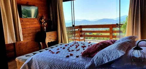 a bedroom with a bed with a view of the mountains at Chalé da Montanha com Ofurô in Santo Amaro da Imperatriz
