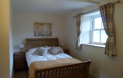 Bett in einem Schlafzimmer mit Fenster in der Unterkunft East Lane Barn in Aysgarth