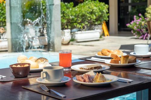 a wooden table with plates of food on it at Praiamar Natal Hotel & Convention in Natal