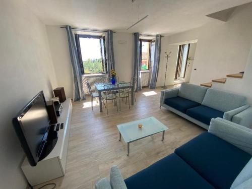 sala de estar con sofá azul y TV en Terrazza Arcius, en Moncalvo