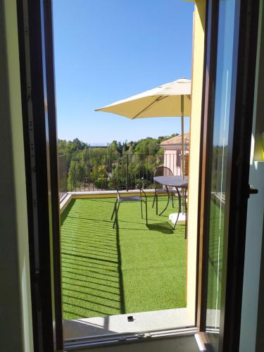 a view from the window of a patio with a table and umbrella at Terrazza Arcius in Moncalvo