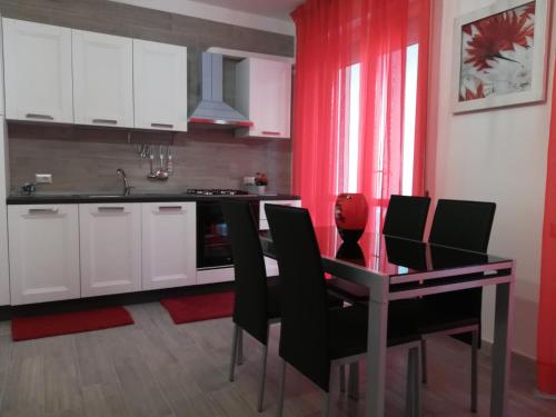 uma cozinha com uma mesa de jantar e cadeiras em Sweet Home QSE em Quartu SantʼElena