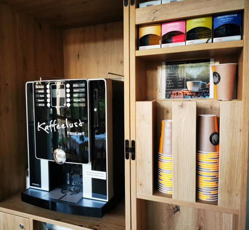 a wooden cabinet with a microwave oven in it at Landgasthof Büttel in Geisfeld