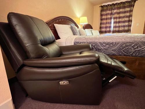 a leather reclining chair in a hotel room with a bed at Frazier View Motel in Frazier Park