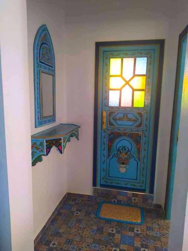 a room with a door with a window and a mirror at Dar Achraf in Chefchaouene