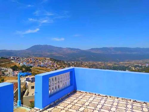a blue balcony with a view of a city at Dar Achraf in Chefchaouene