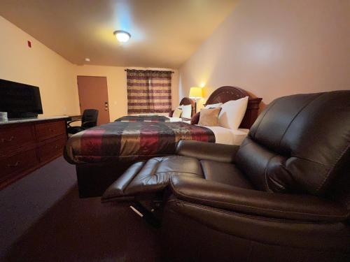 a hotel room with a bed and a leather chair at Frazier View Motel in Frazier Park