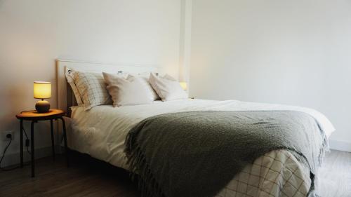 a bedroom with a bed with a lamp on a table at SINTRA STAY - Massamá Guesthouse in Queluz