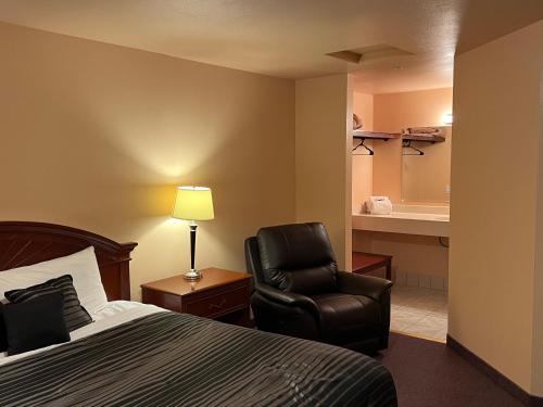 a hotel room with a bed and a chair at Frazier View Motel in Frazier Park