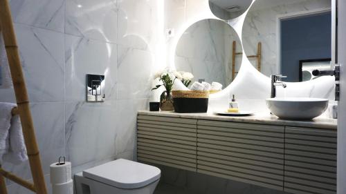 a bathroom with a sink and a toilet and a mirror at SINTRA STAY - Massamá Guesthouse in Queluz