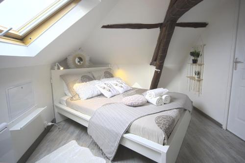 サンスにあるMon Rêve - By BEST KEYS - Loft Cosy & Charme Authentique - Poutres Apparentes - Centre Ville - Netflix & WiFi Fibre - Smart TV - Machine à Café Nespresso - Check-in Autonome - Parking Facile & Gratuitの白いベッドと枕のある寝室