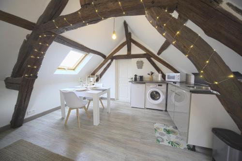 une cuisine avec une table et une machine à laver dans l'établissement Mon Rêve - By BEST KEYS - Loft Cosy & Charme Authentique - Poutres Apparentes - Centre Ville - Netflix & WiFi Fibre - Smart TV - Machine à Café Nespresso - Check-in Autonome - Parking Facile & Gratuit, à Sens