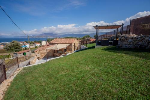 a view of a house with a green lawn at Casa mirador Tía Amalia in Carnota