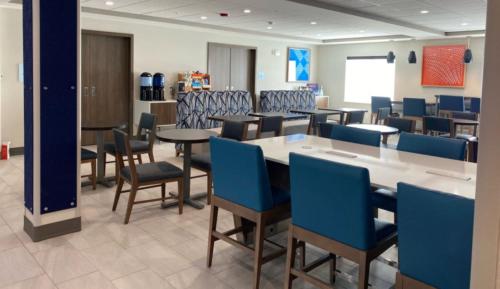 a dining room with tables and blue chairs at Holiday Inn Express Hotel & Suites Grand Junction by IHG in Grand Junction